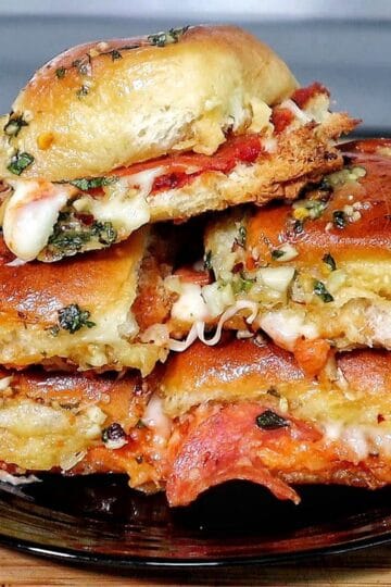 Pull-apart pizza sliders made with Hawaiian rolls, layered with melted mozzarella, pepperoni, pizza sauce, and brushed with a garlic herb butter topping.
