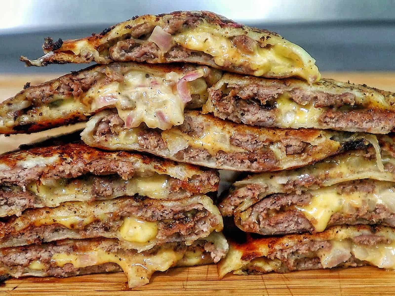 Smashburger quesadillas filled with seasoned ground beef, melted American cheese, diced onions, in a crispy toasted tortilla.
