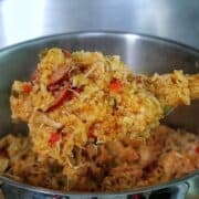Southern Chicken Bog served on a white plate, featuring tender shredded chicken, sliced andouille sausage, and seasoned rice with bell peppers