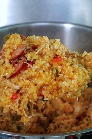Southern Chicken Bog served on a white plate, featuring tender shredded chicken, sliced andouille sausage, and seasoned rice with bell peppers