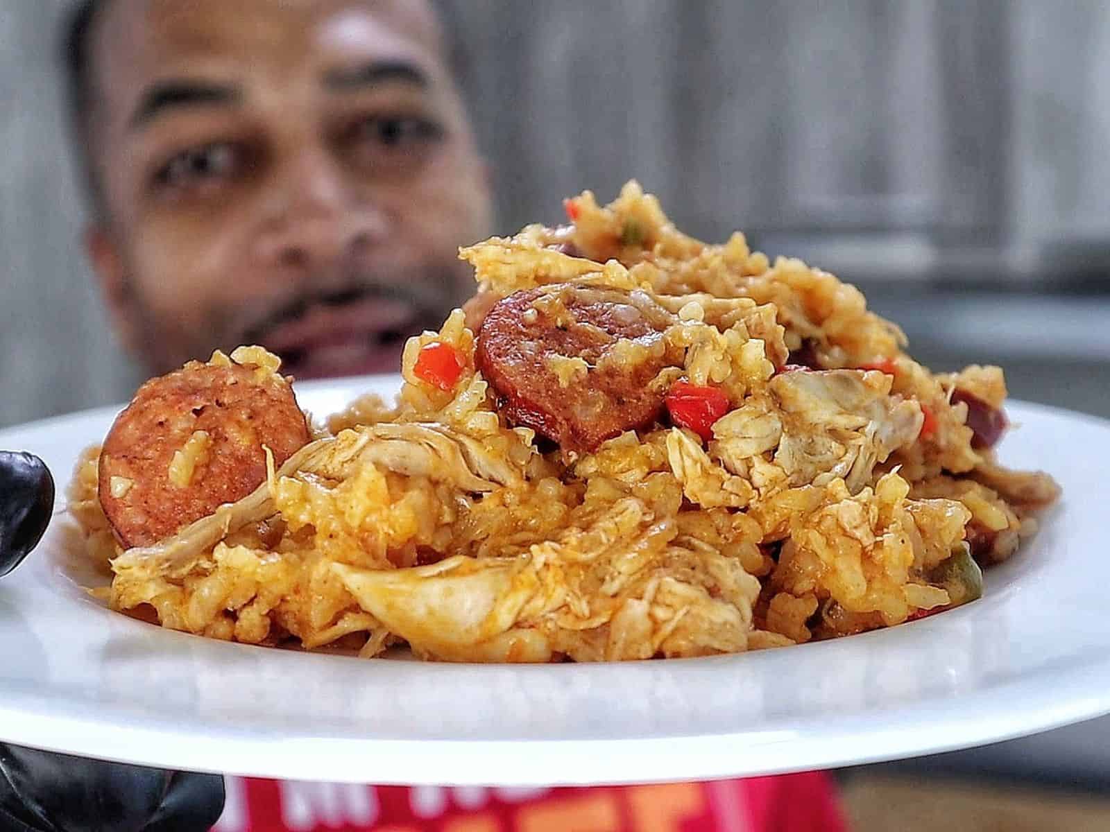 Southern Chicken Bog served on a white plate, featuring tender shredded chicken, sliced andouille sausage, and seasoned rice with bell peppers.