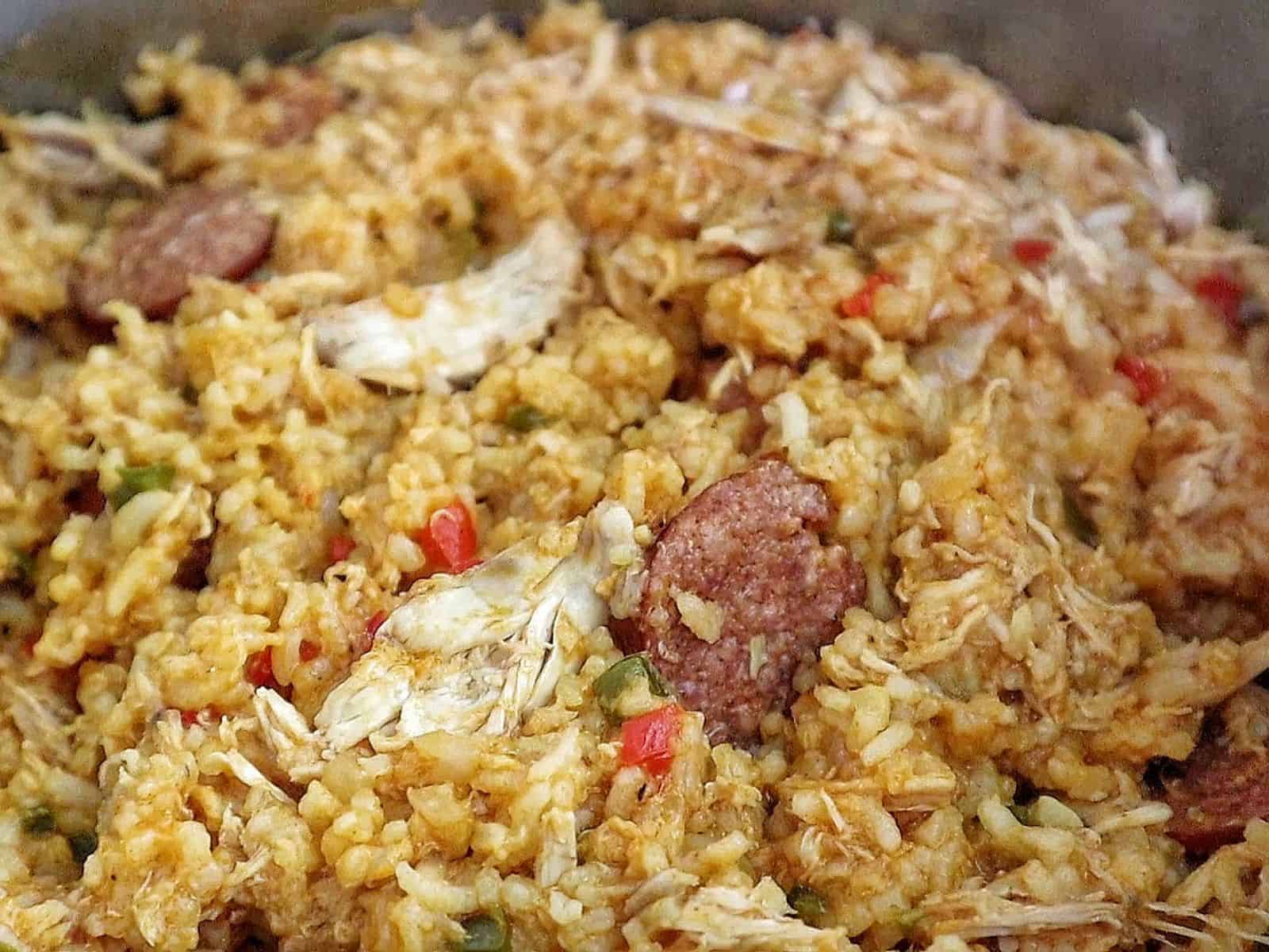 Southern Chicken Bog served on a white plate, featuring tender shredded chicken, sliced andouille sausage, and seasoned rice with bell peppers.