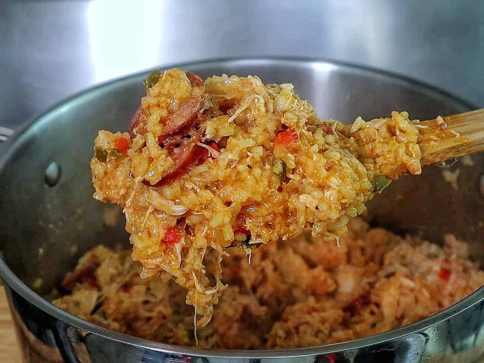 Southern Chicken Bog served on a white plate, featuring tender shredded chicken, sliced andouille sausage, and seasoned rice with bell peppers.