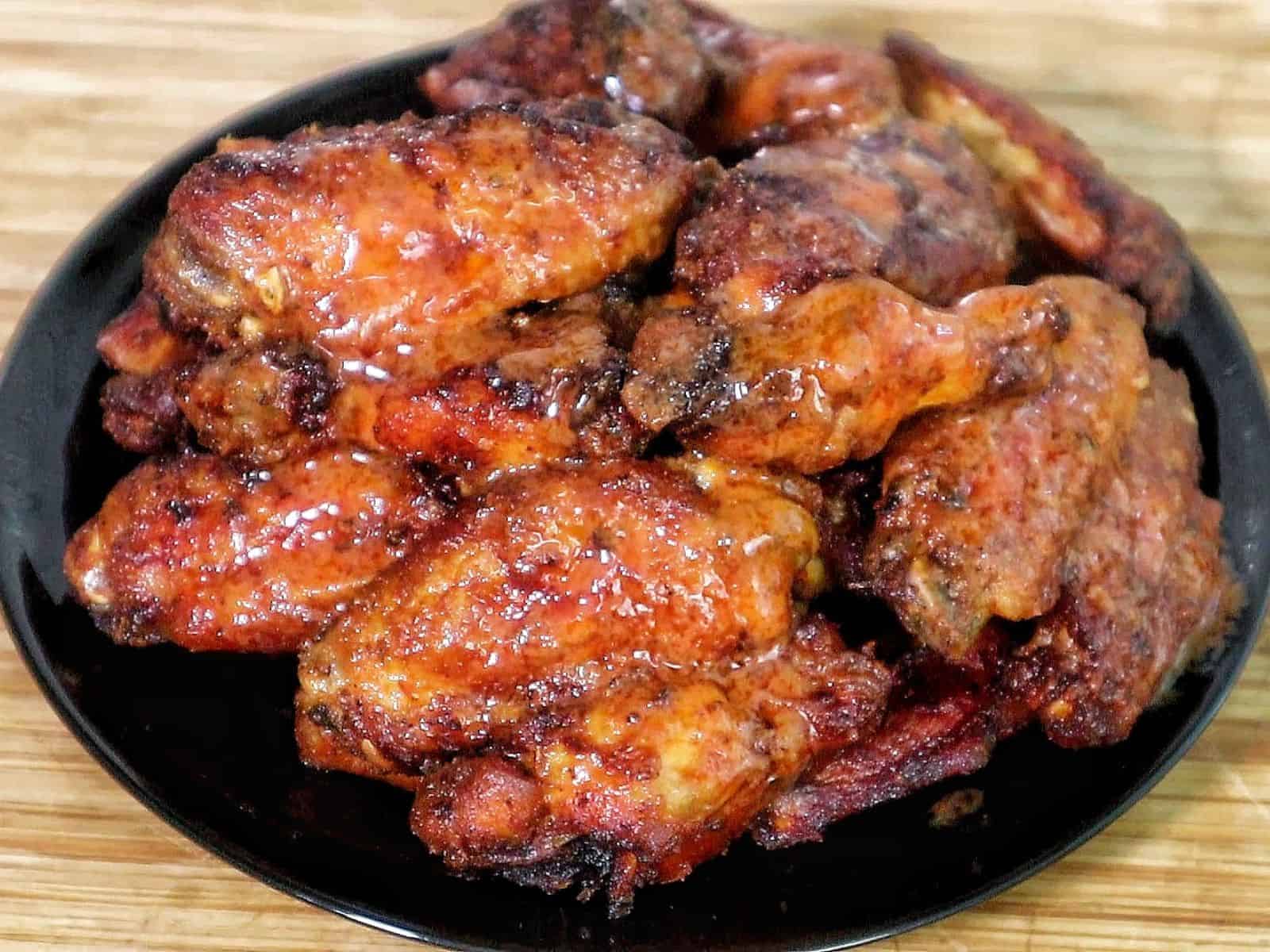 Crispy air-fried spicy blackened chicken wings coated in a buttery hot sauce glaze, served fresh and ready to eat.