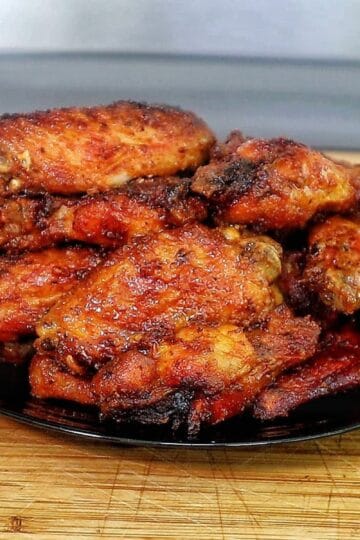 Crispy air-fried spicy blackened chicken wings coated in a buttery hot sauce glaze, served fresh and ready to eat.