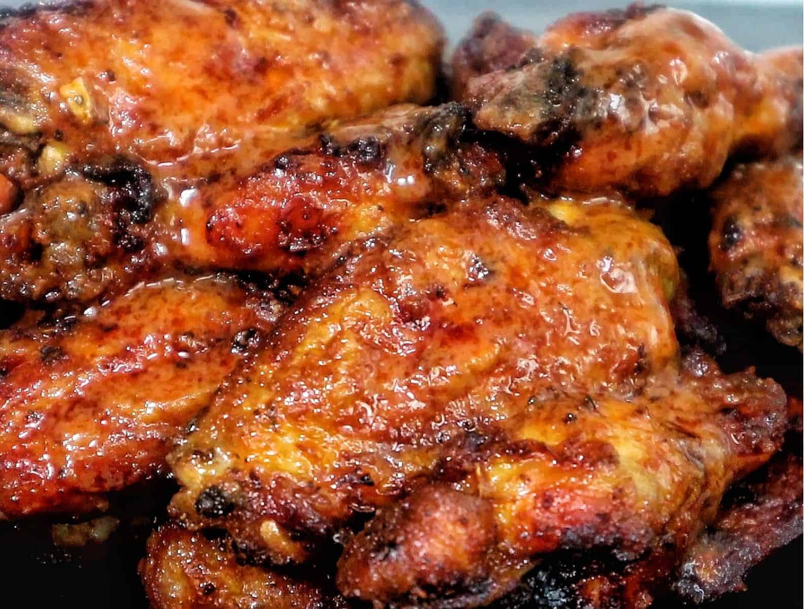 Crispy air-fried spicy blackened chicken wings coated in a buttery hot sauce glaze, served fresh and ready to eat.