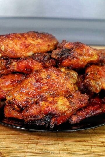 Crispy air-fried spicy blackened chicken wings coated in a buttery hot sauce glaze, served fresh and ready to eat.