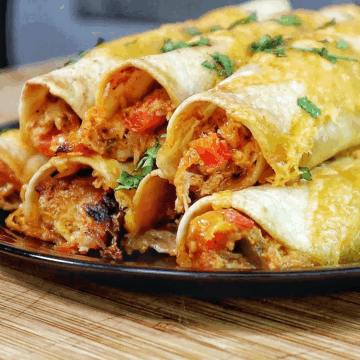 Golden brown crispy chicken taquitos filled with shredded chicken and red peppers, topped with melted cheese and fresh chopped cilantro.