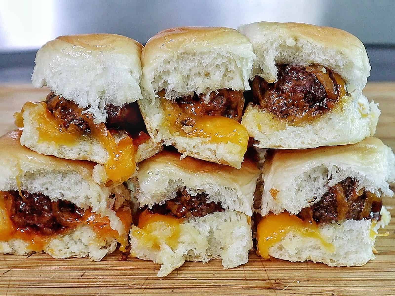 cheesy sweet and spicy BBQ meatball sliders baked inside soft Hawaiian rolls, topped with melted cheddar