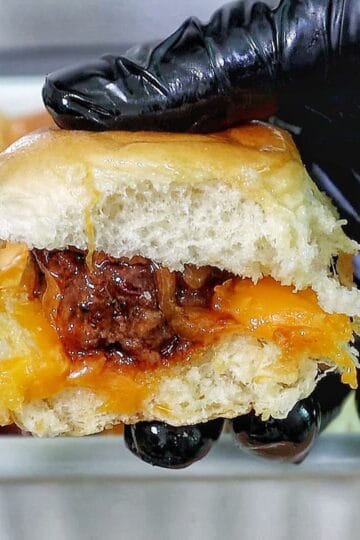 cheesy sweet and spicy BBQ meatball sliders baked inside soft Hawaiian rolls, topped with melted cheddar