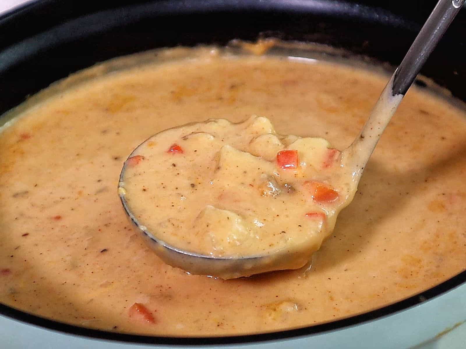 Creamy Cajun potato soup topped with crispy bacon, cheddar cheese, and green onions
