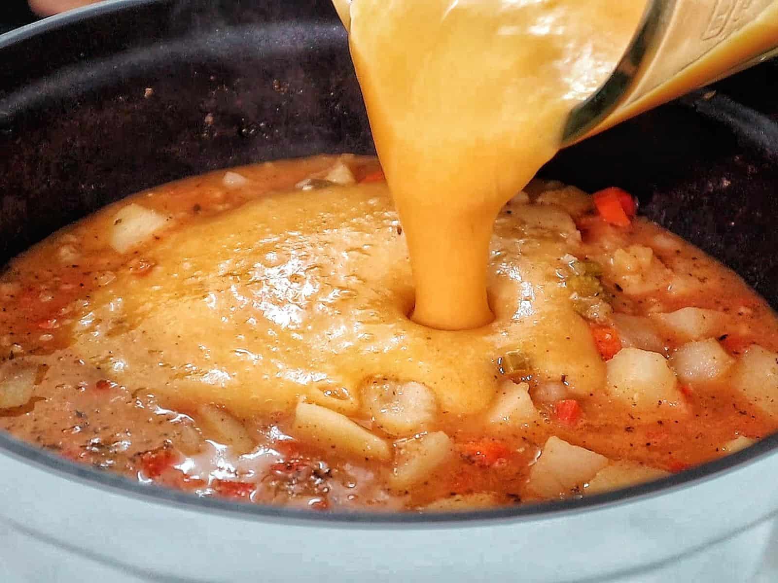 Creamy Cajun potato soup topped with crispy bacon, cheddar cheese, and green onions