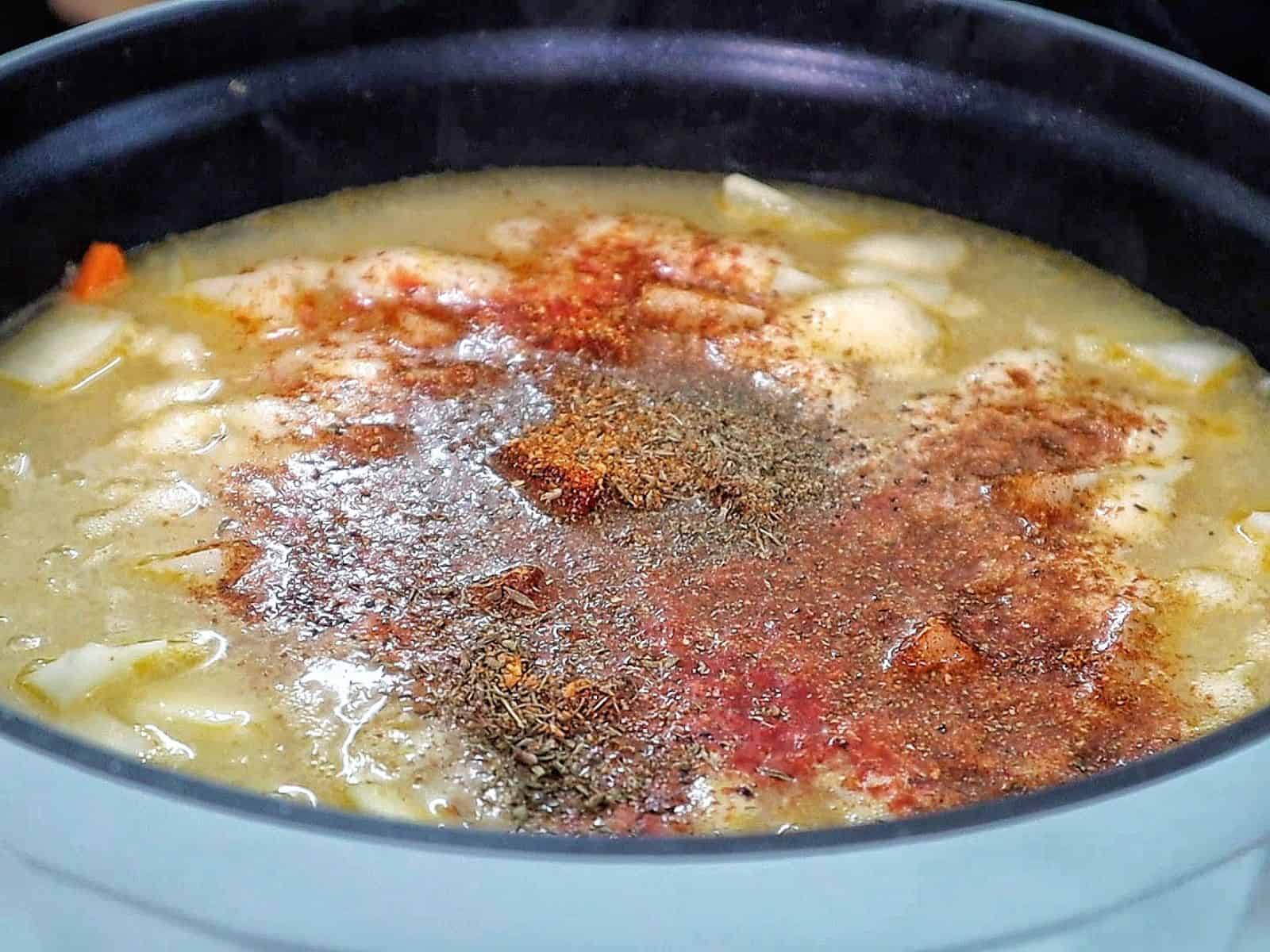 Creamy Cajun potato soup topped with crispy bacon, cheddar cheese, and green onions