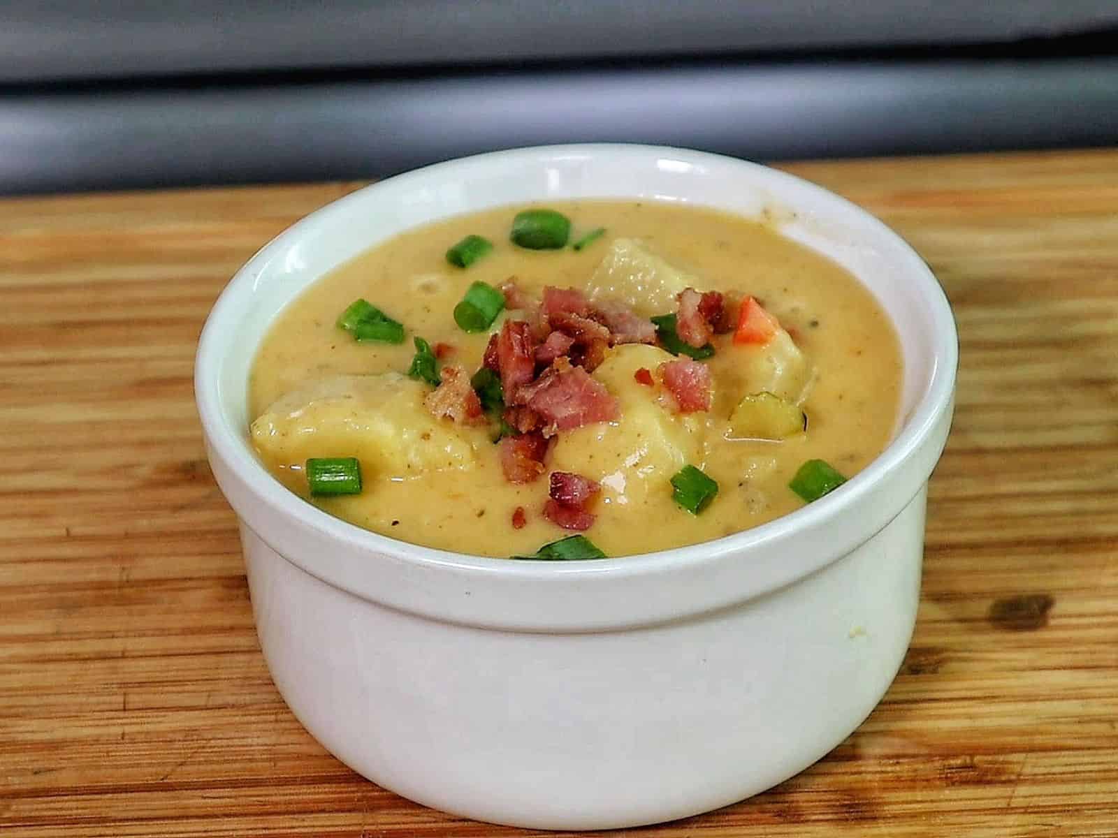 Creamy Cajun potato soup topped with crispy bacon, cheddar cheese, and green onions