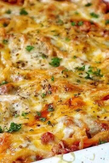 Cheesy baked spaghetti casserole with seasoned ground beef, tomato sauce, and melted mozzarella, cheddar, and parmesan.