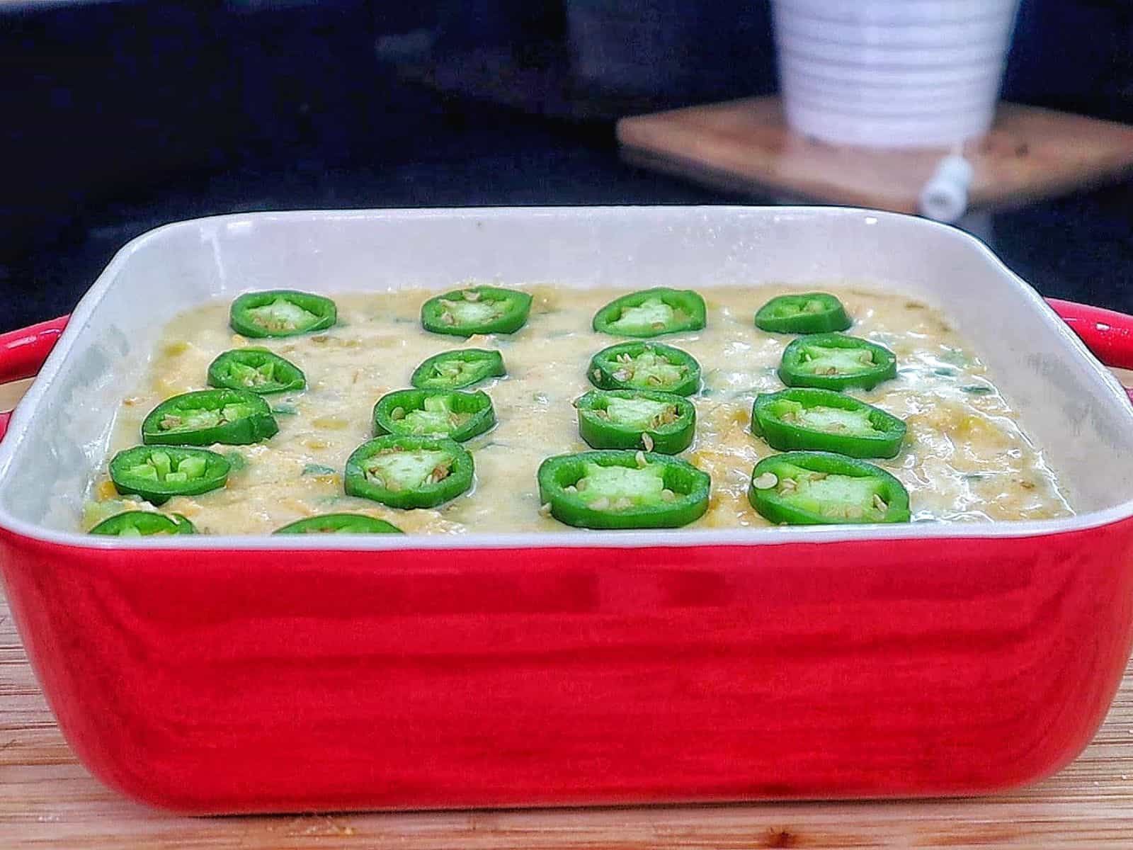 Golden cheesy jalapeño cornbread slice topped with fresh jalapeño rounds, baked until crispy on top and soft inside.
