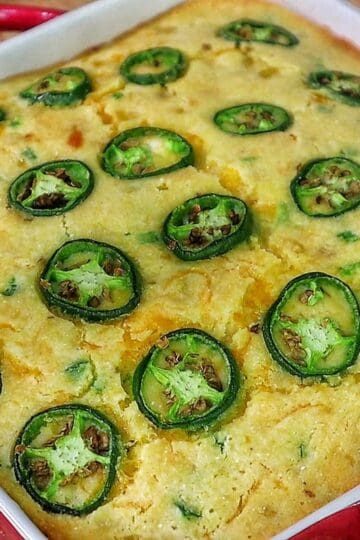 Golden cheesy jalapeño cornbread slice topped with fresh jalapeño rounds, baked until crispy on top and soft inside.