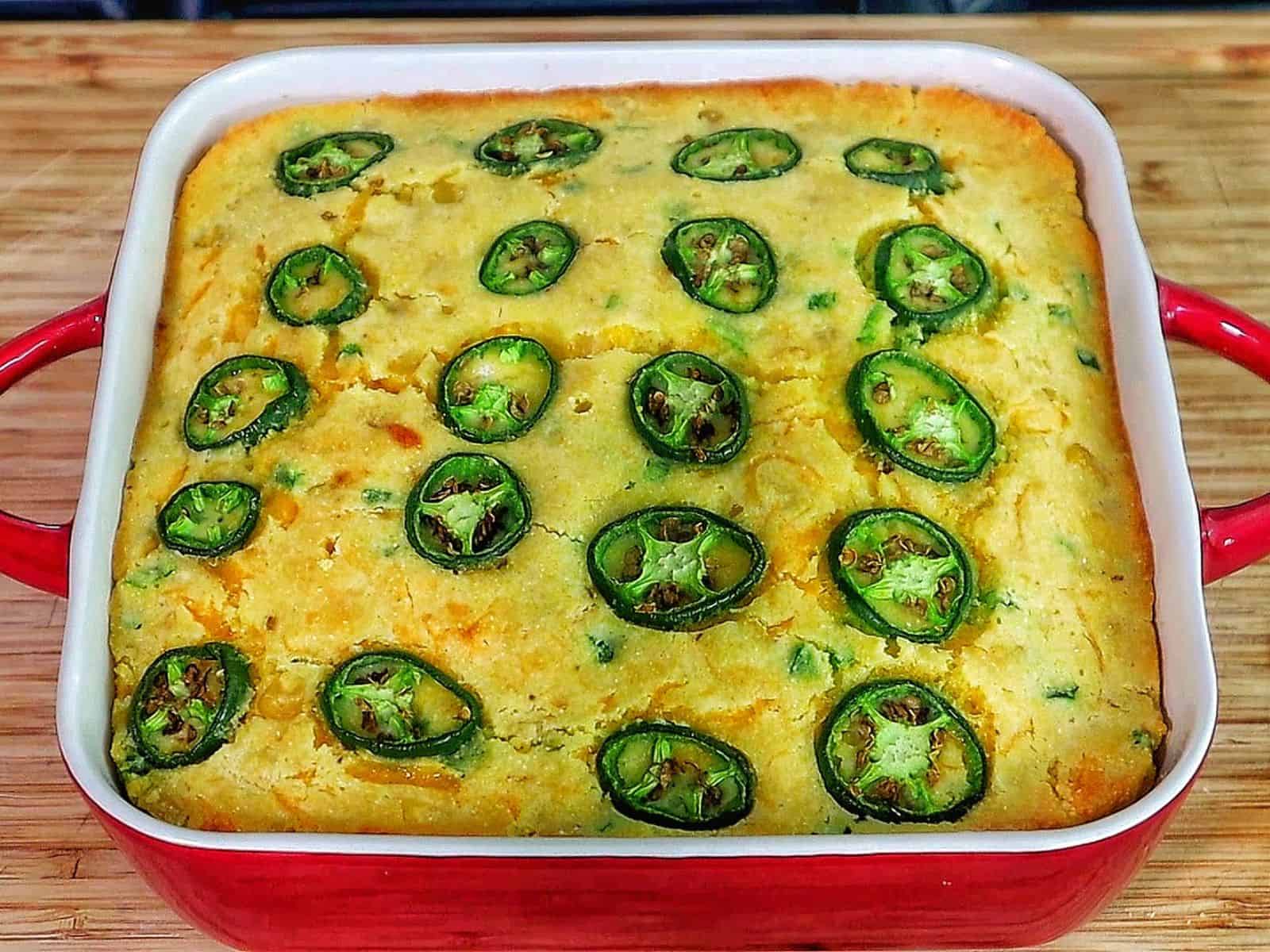 Golden cheesy jalapeño cornbread slice topped with fresh jalapeño rounds, baked until crispy on top and soft inside. 