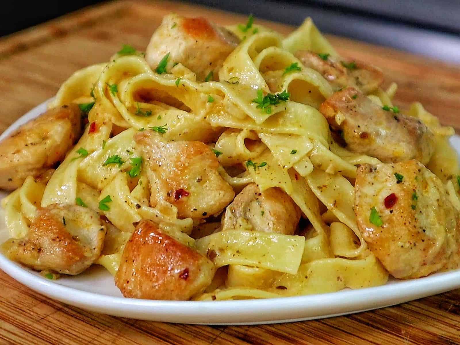Creamy cowboy butter chicken pasta with tender seared chicken pieces tossed with fettuccine noodles in a rich buttery garlic cream sauce and garnished with fresh parsley.