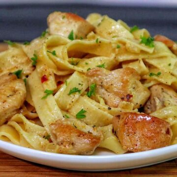 Creamy cowboy butter chicken pasta with tender seared chicken pieces tossed with fettuccine noodles in a rich buttery garlic cream sauce and garnished with fresh parsley.