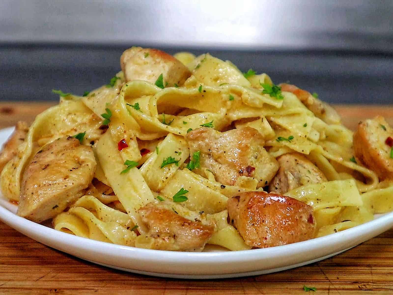 Creamy cowboy butter chicken pasta with tender seared chicken pieces tossed with fettuccine noodles in a rich buttery garlic cream sauce and garnished with fresh parsley.