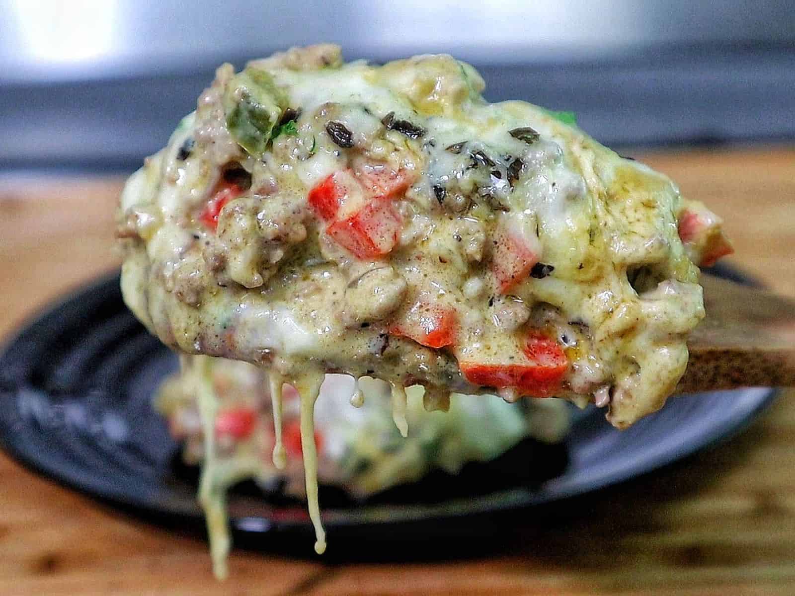 Cheesy Philly cheesesteak casserole with ground beef, bell peppers, mushrooms, and melted provolone and mozzarella cheese.