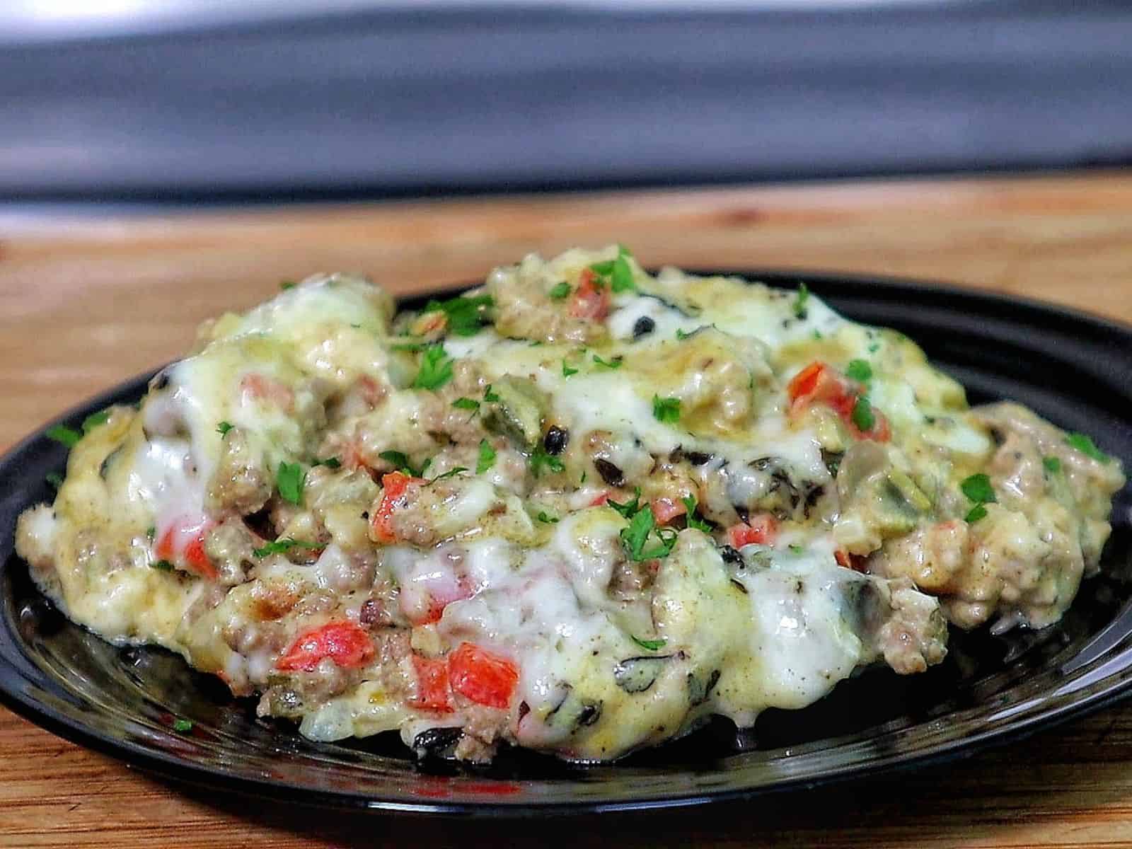 Cheesy Philly cheesesteak casserole with ground beef, bell peppers, mushrooms, and melted provolone and mozzarella cheese.