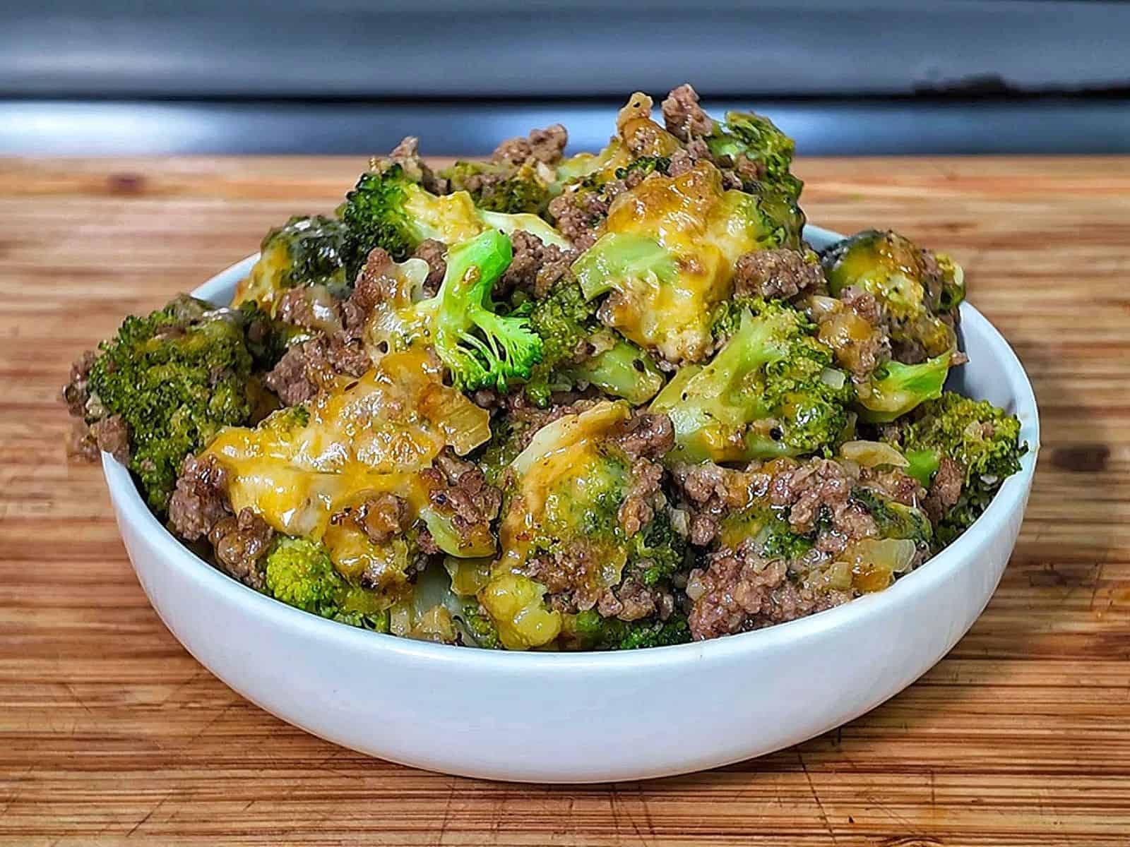 Cheesy ground beef and broccoli skillet with melted cheddar and colby jack cheese, cooked in a pan.