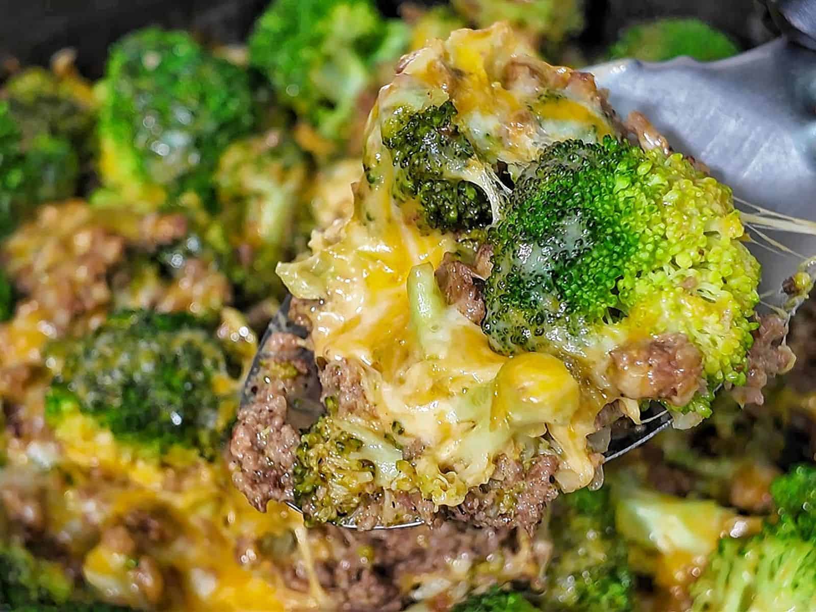 Cheesy ground beef and broccoli skillet with melted cheddar and colby jack cheese, cooked in a pan.