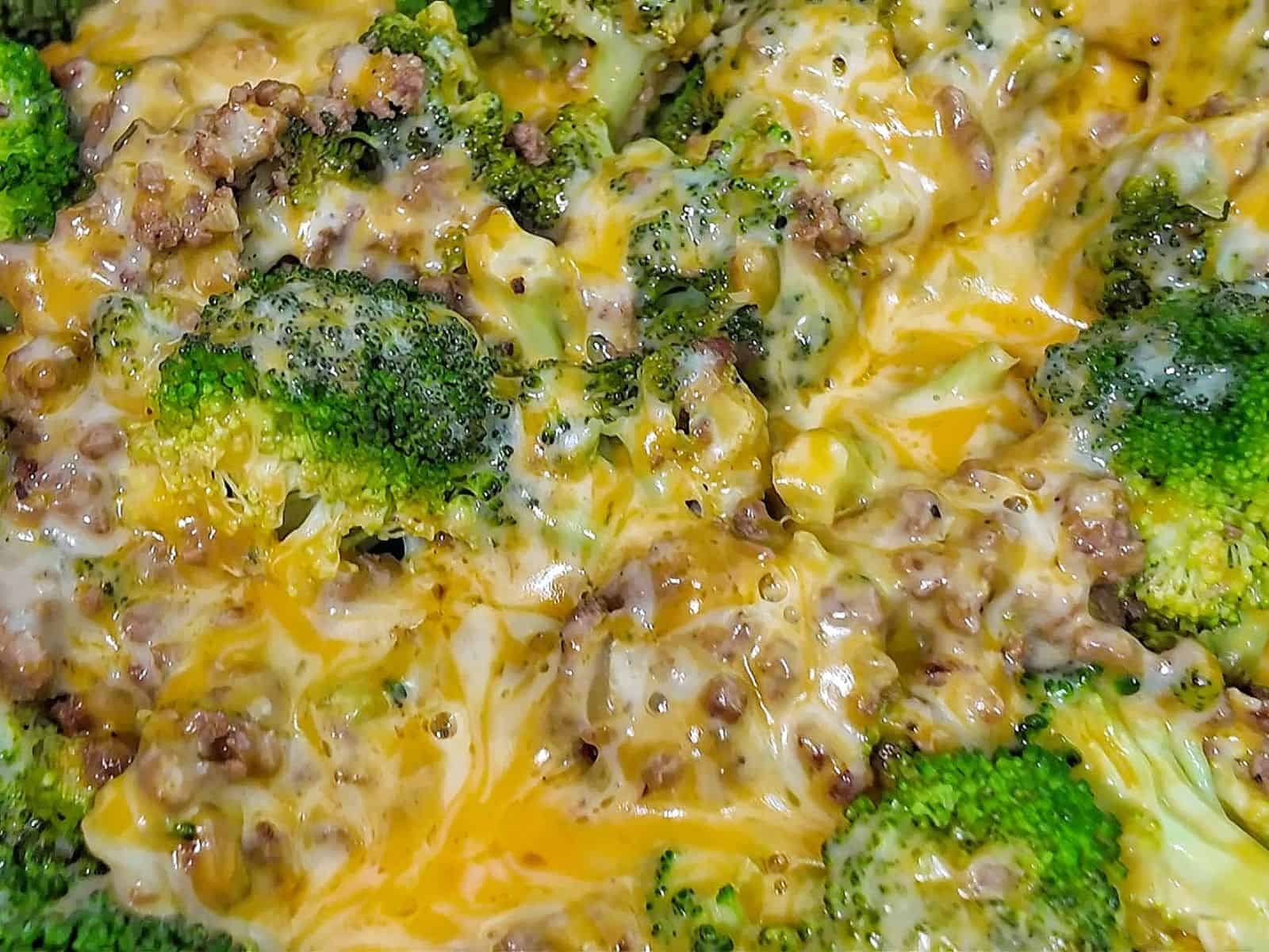 Cheesy ground beef and broccoli skillet with melted cheddar and colby jack cheese, cooked in a pan.
