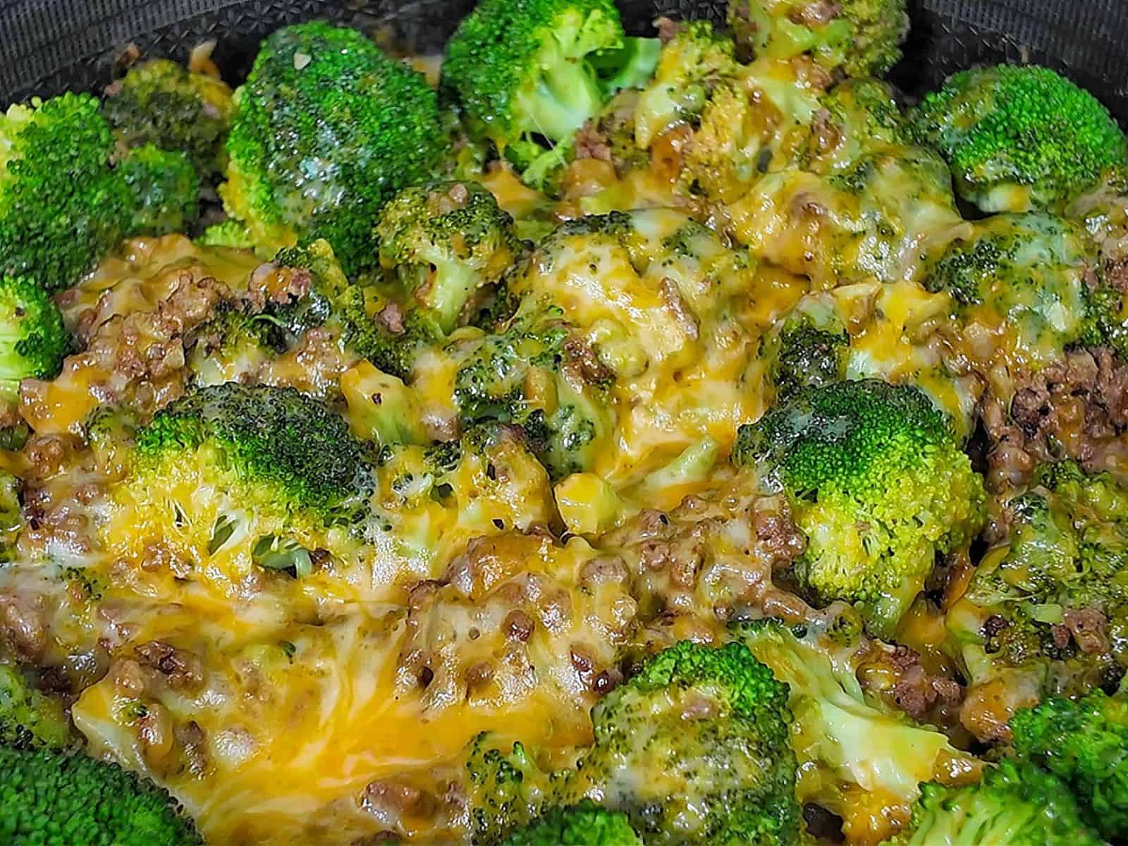 Cheesy ground beef and broccoli skillet with melted cheddar and colby jack cheese, cooked in a pan.