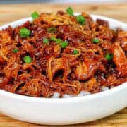 Shredded crockpot BBQ chicken coated in a rich Sweet Baby Ray’s sauce, served over white rice and topped with chopped green onions.