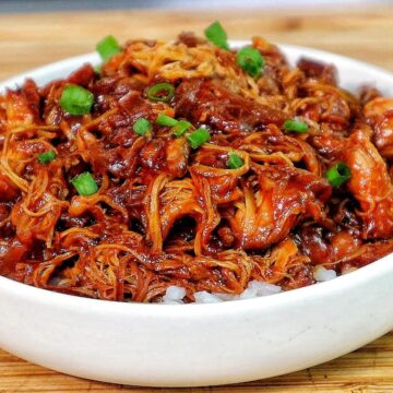 Shredded crockpot BBQ chicken coated in a rich Sweet Baby Ray’s sauce, served over white rice and topped with chopped green onions.