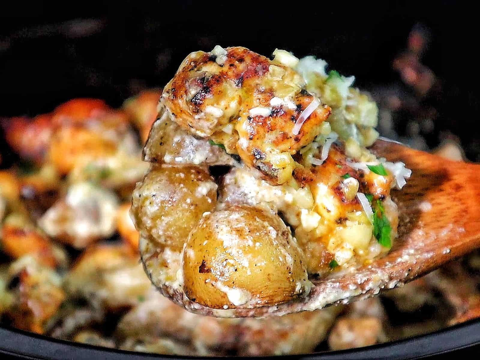 Creamy garlic parmesan chicken and baby potatoes, seared and coated in a rich sauce, garnished with parsley.