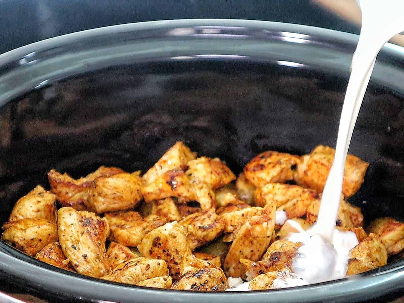 Creamy garlic parmesan chicken and baby potatoes, seared and coated in a rich sauce, garnished with parsley.