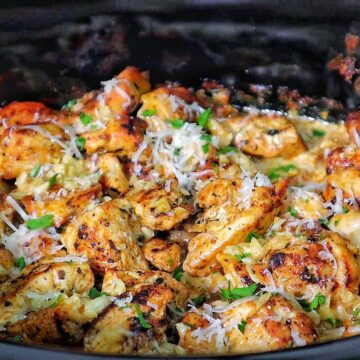 Creamy garlic parmesan chicken and baby potatoes, seared and coated in a rich sauce, garnished with parsley.
