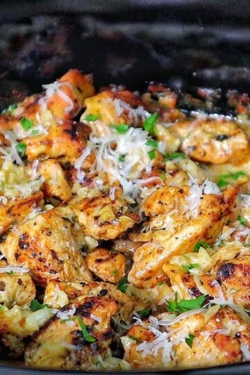 Creamy garlic parmesan chicken and baby potatoes, seared and coated in a rich sauce, garnished with parsley.