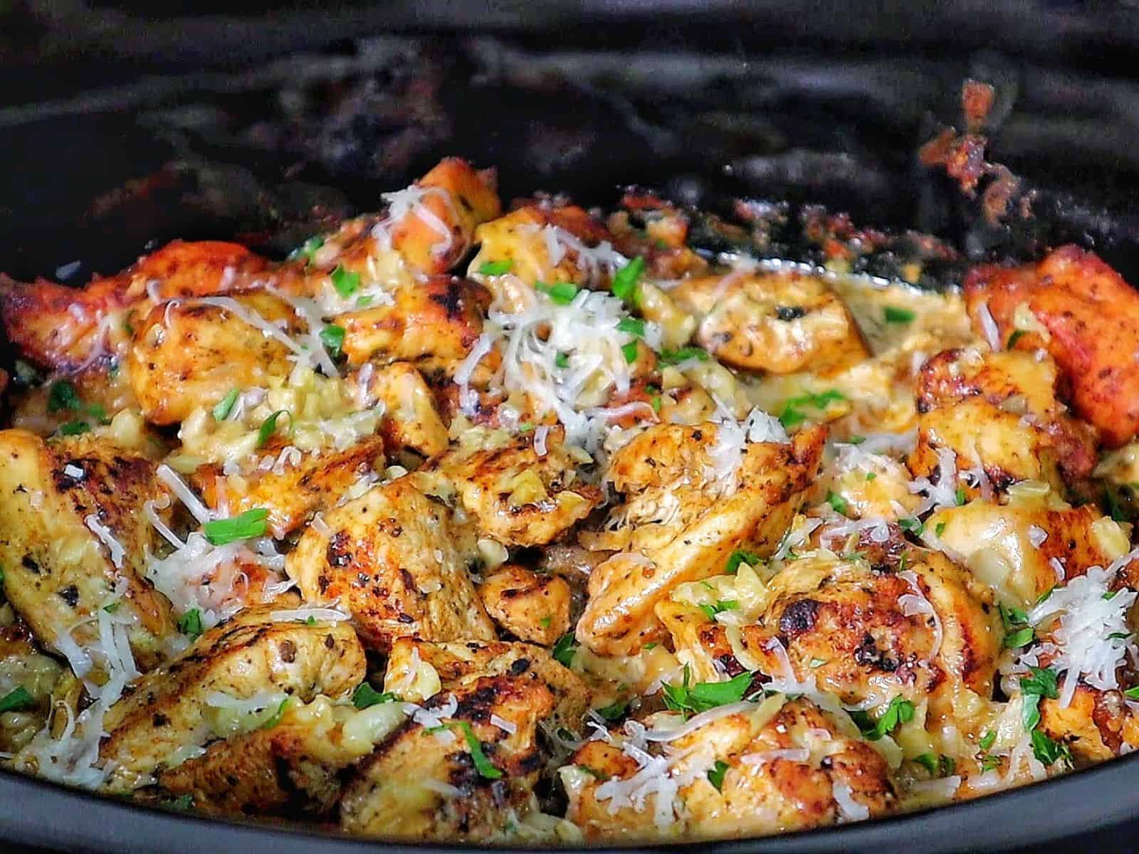 Creamy garlic parmesan chicken and baby potatoes, seared and coated in a rich sauce, garnished with parsley.
