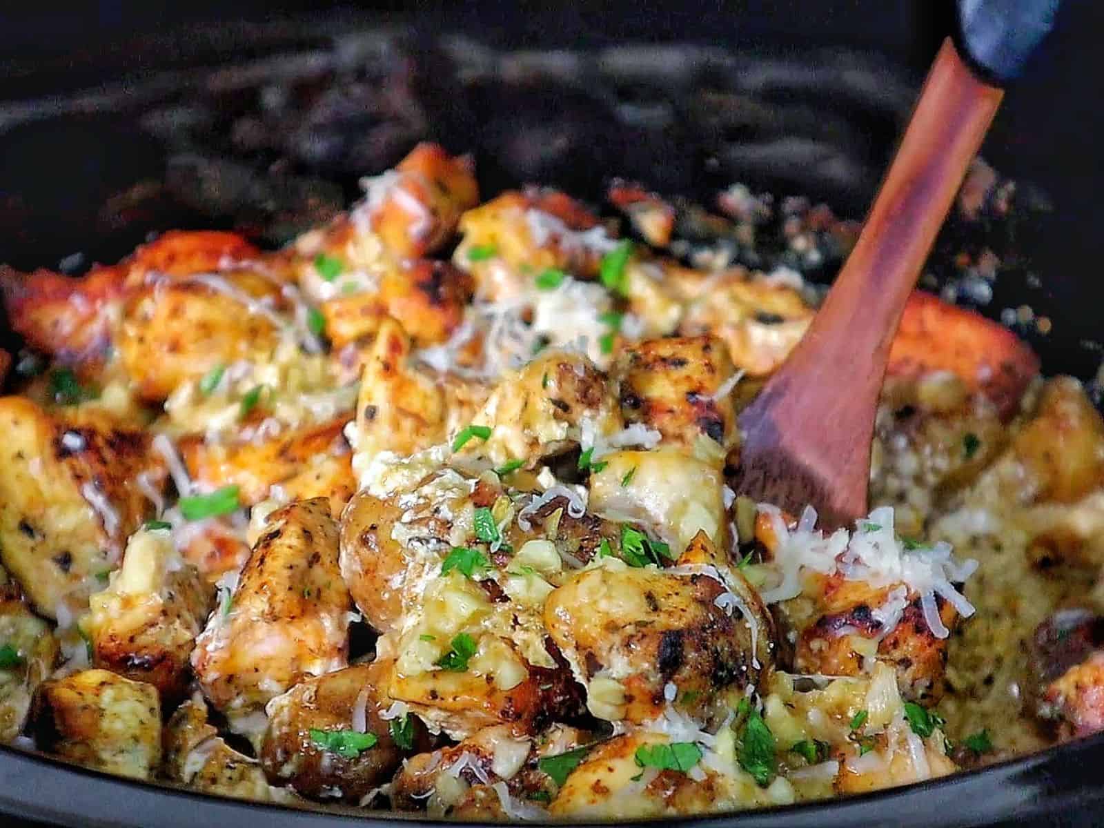 Creamy garlic parmesan chicken and baby potatoes, seared and coated in a rich sauce, garnished with parsley.