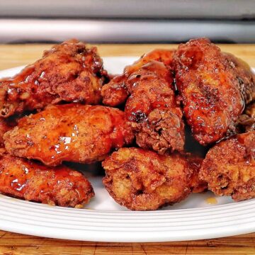 Crispy fried chicken wings coated in a glossy sticky Hennessy glaze.