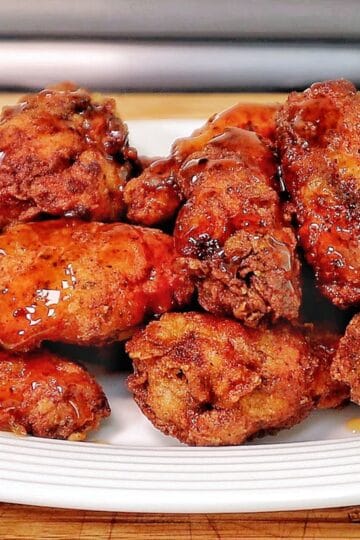 Crispy fried chicken wings coated in a glossy sticky Hennessy glaze.
