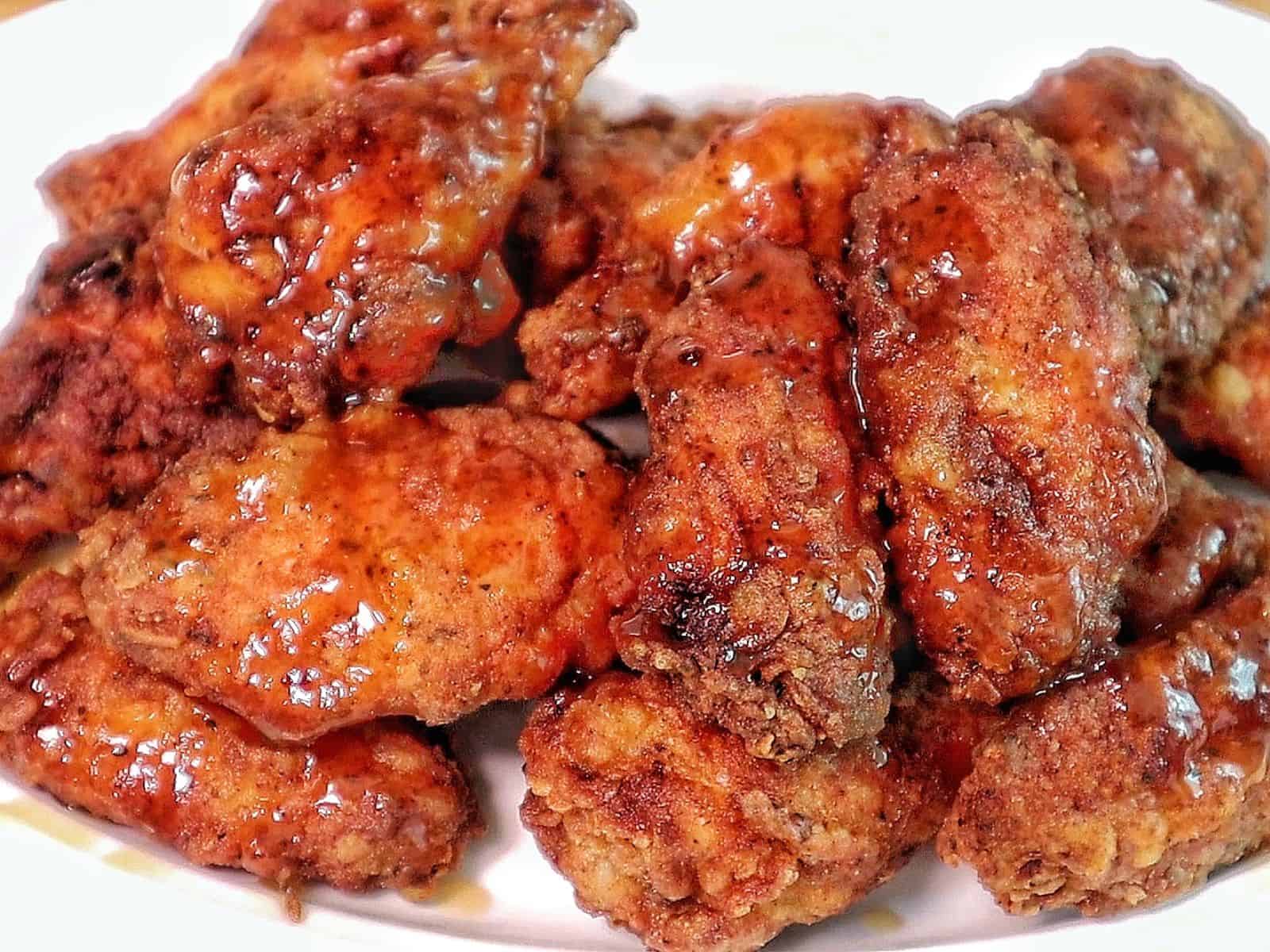 Crispy fried chicken wings coated in a glossy sticky Hennessy glaze.