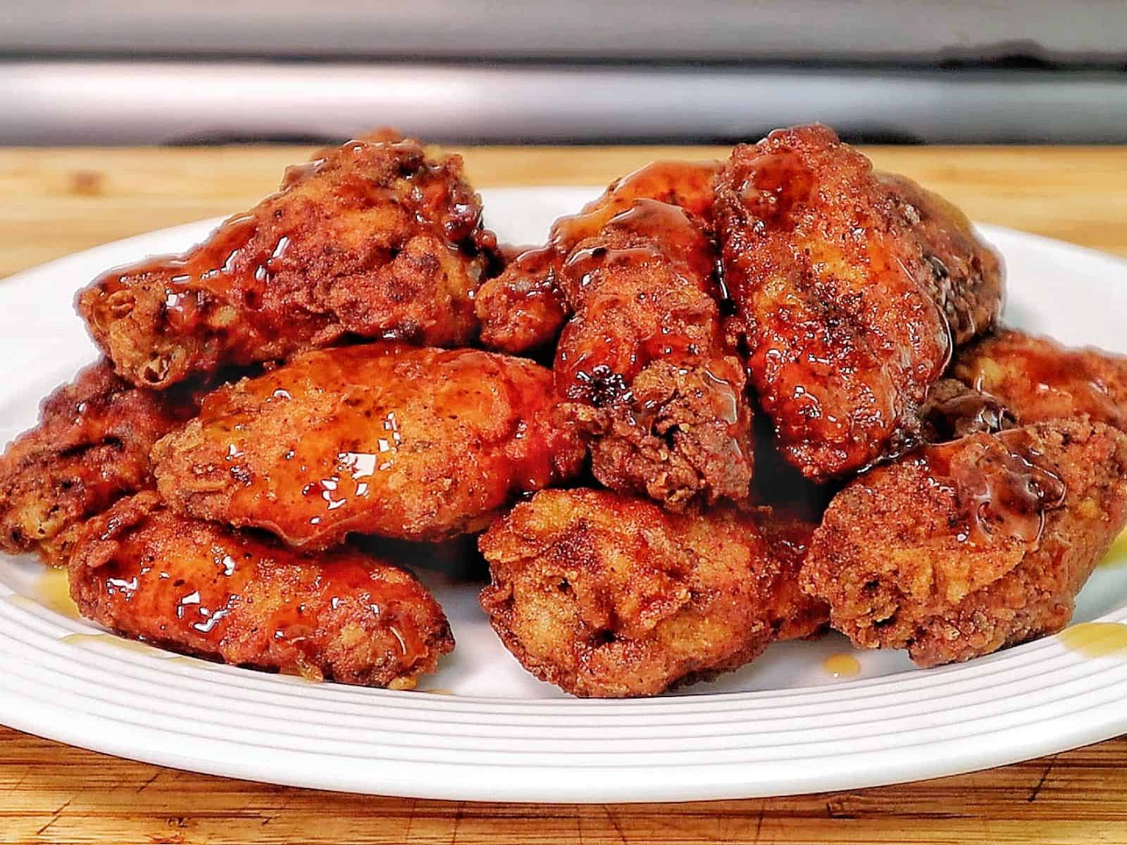 Crispy fried chicken wings coated in a glossy sticky Hennessy glaze.