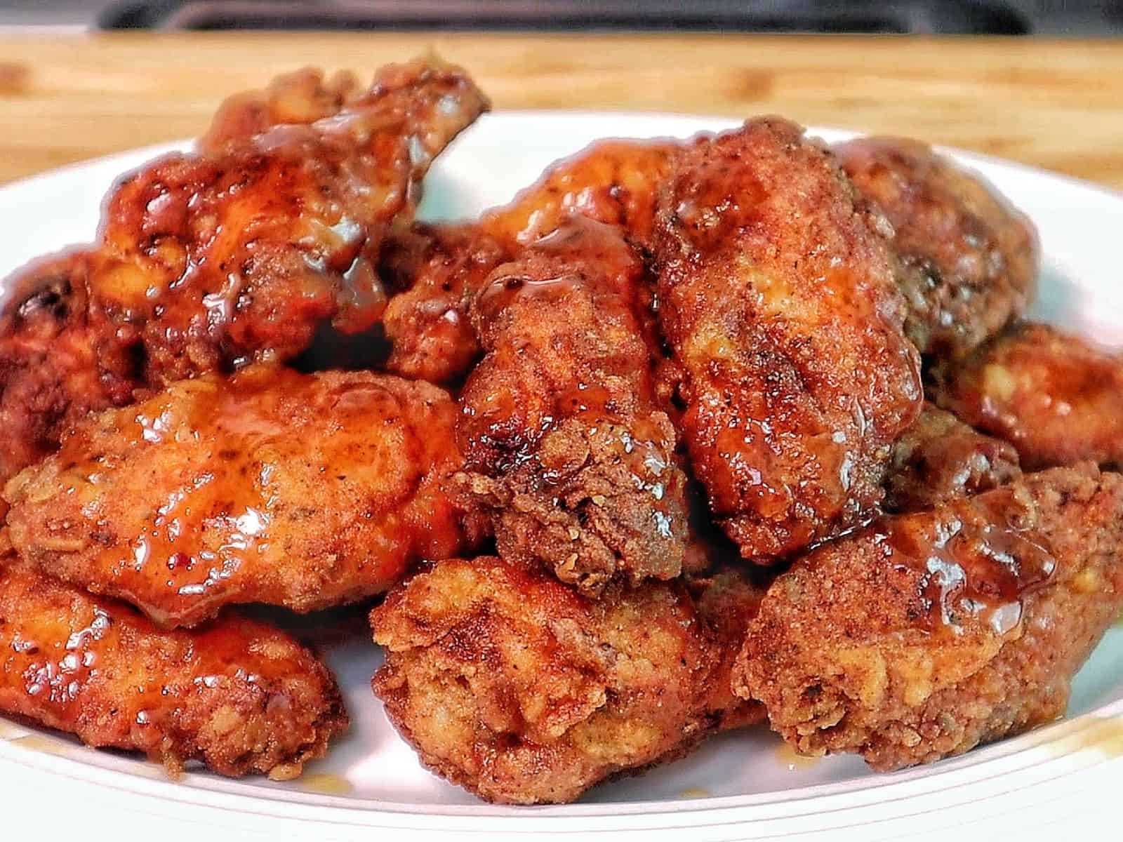 Crispy fried chicken wings coated in a glossy sticky Hennessy glaze.