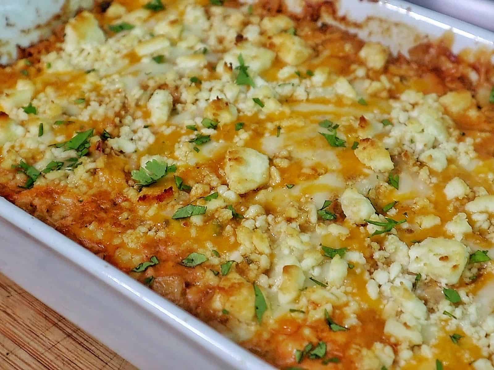 Creamy street corn chicken casserole baked with melted cheese, corn, shredded chicken, and garnished with cilantro.