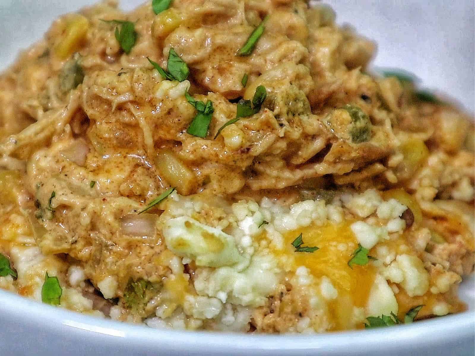 Creamy street corn chicken casserole baked with melted cheese, corn, shredded chicken, and garnished with cilantro.