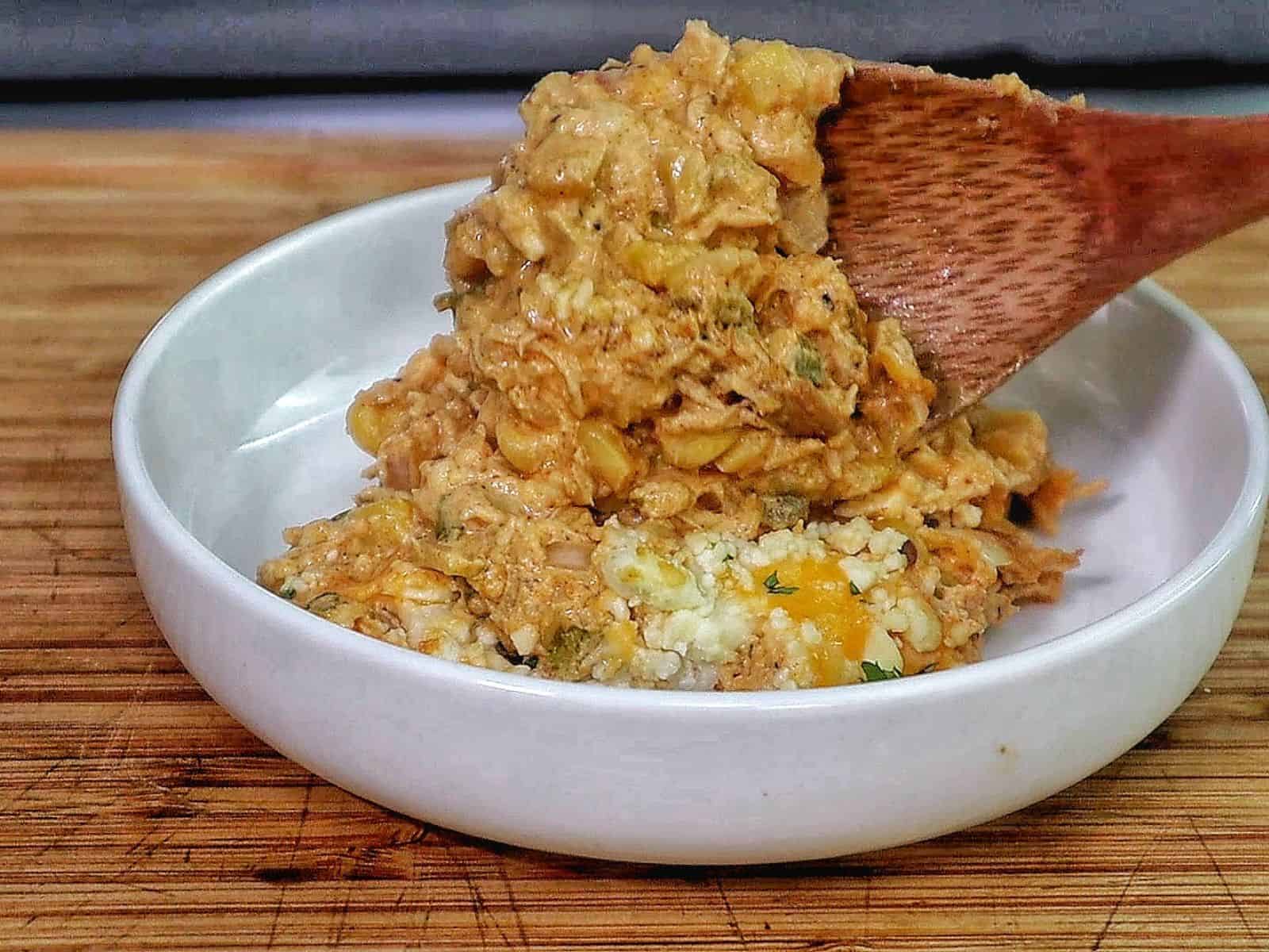 Creamy street corn chicken casserole baked with melted cheese, corn, shredded chicken, and garnished with cilantro.