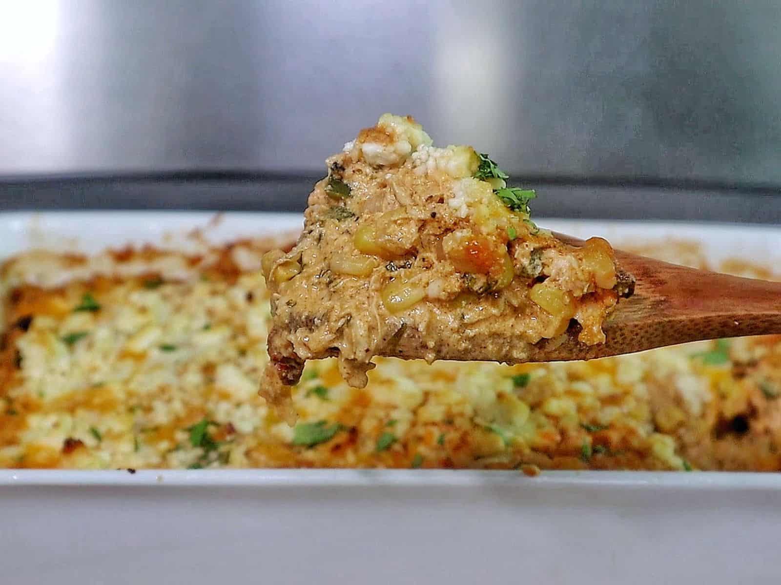 Creamy street corn chicken casserole baked with melted cheese, corn, shredded chicken, and garnished with cilantro.