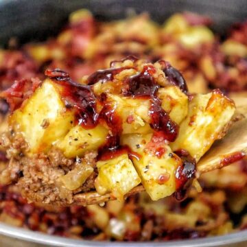 BBQ Cheeseburger Potato Skillet loaded with crispy potatoes, seasoned ground beef, melted Colby Jack cheese, bacon crumbles, crispy fried onions, and drizzled BBQ sauce