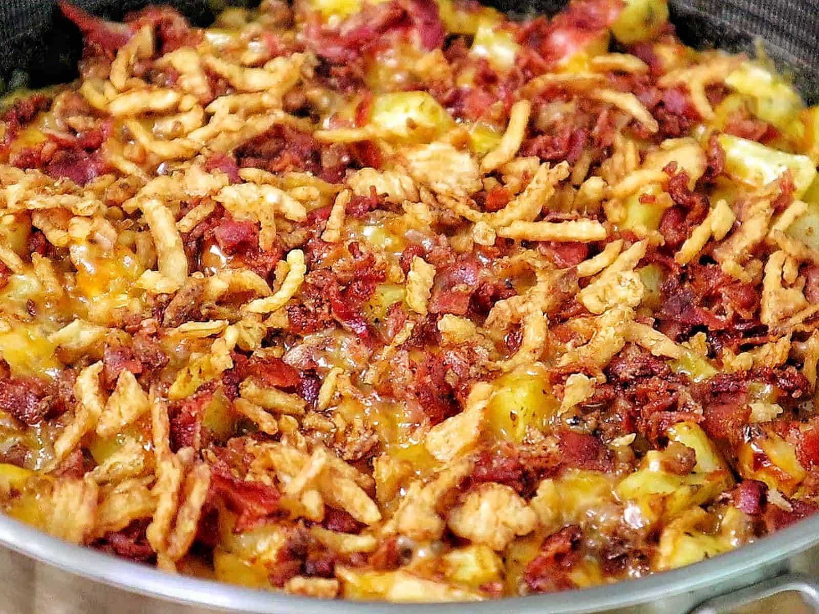 BBQ Cheeseburger Potato Skillet loaded with crispy potatoes, seasoned ground beef, melted Colby Jack cheese, bacon crumbles, crispy fried onions, and drizzled BBQ sauce.